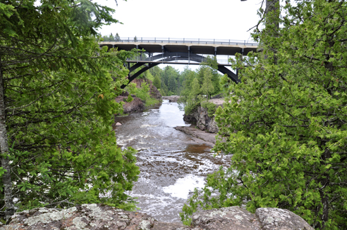 the water from the upper falls going under a roadway