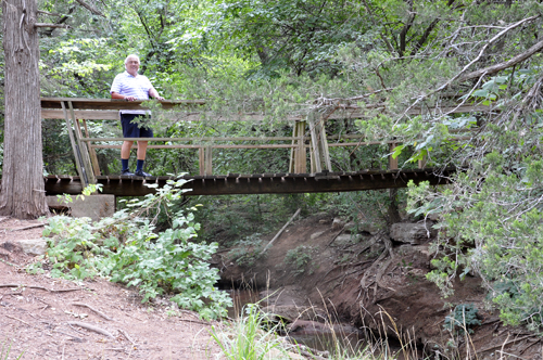 Lee Duquette crosses the wooden bridge