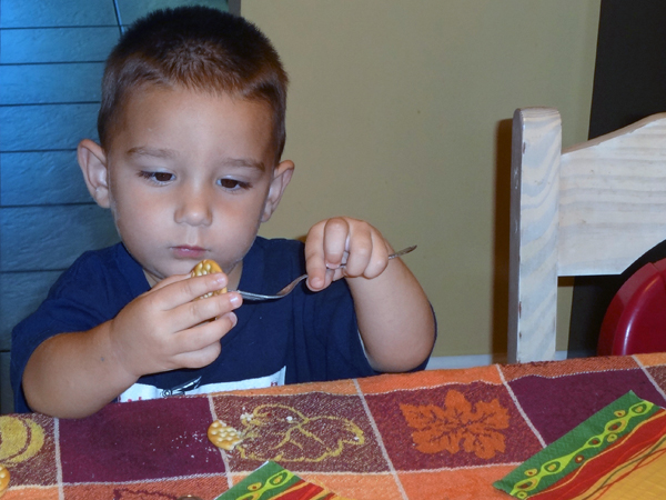 Anthony feeding himself a cracker on a fcrk