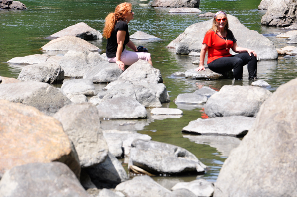Karen and her sister relaxing on the rocks with their feet in the water