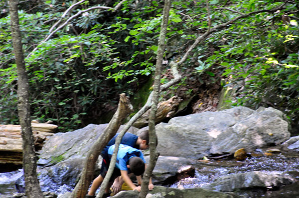 The boys crawling over the big boulders