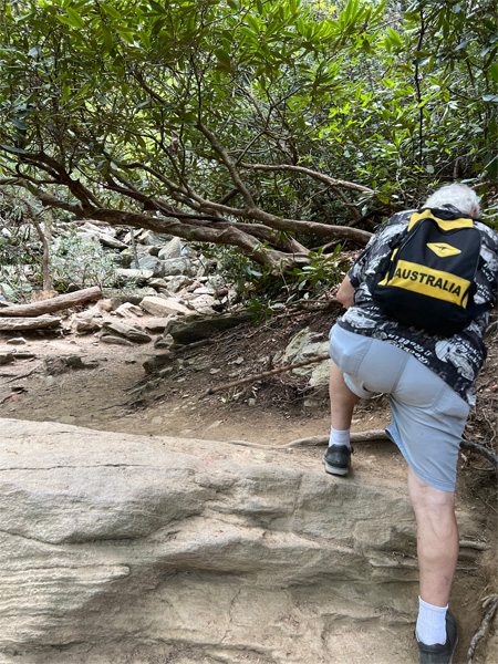 Lee Duquette high stepping up a boulder