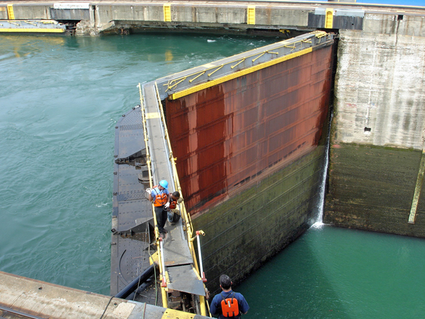 workers on the top ledge of the gate