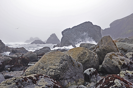the big rocks by the ocean take a beating from the waves